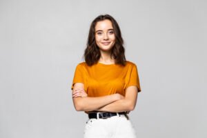 Beautiful young woman standing on grey background