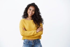 Happiness, wellbeing and confidence concept. Cheerful attractive african american woman curly haircut, cross arms chest in self-assured powerful pose, smiling determined, wear yellow sweater.